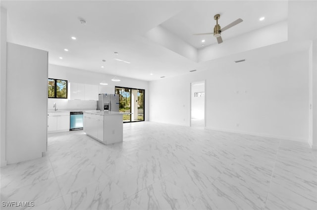 unfurnished living room featuring sink, a raised ceiling, and ceiling fan