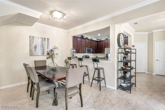 dining area featuring light tile patterned floors and crown molding