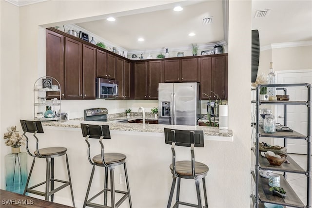 kitchen featuring a breakfast bar area, appliances with stainless steel finishes, and kitchen peninsula