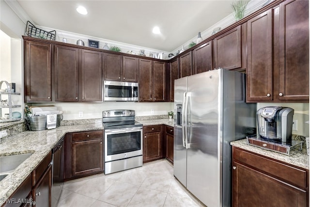 kitchen with light stone countertops, dark brown cabinetry, appliances with stainless steel finishes, light tile patterned flooring, and crown molding