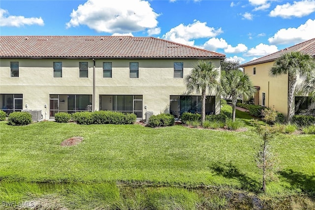 back of property with a yard and central air condition unit