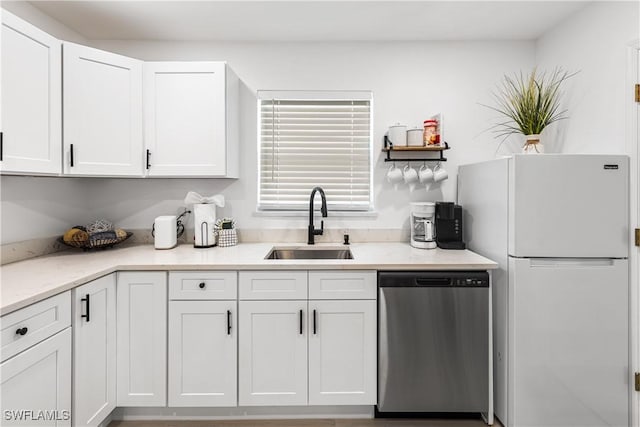 kitchen with sink, white cabinetry, stainless steel dishwasher, and white refrigerator