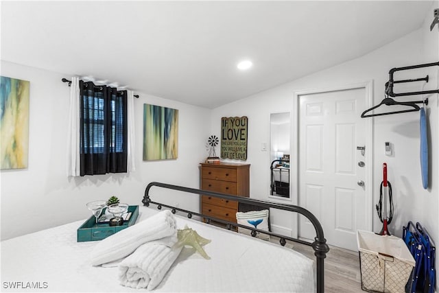 bedroom with hardwood / wood-style floors and vaulted ceiling