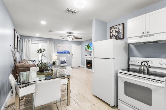 kitchen with ceiling fan, white appliances, white cabinets, and light tile patterned flooring