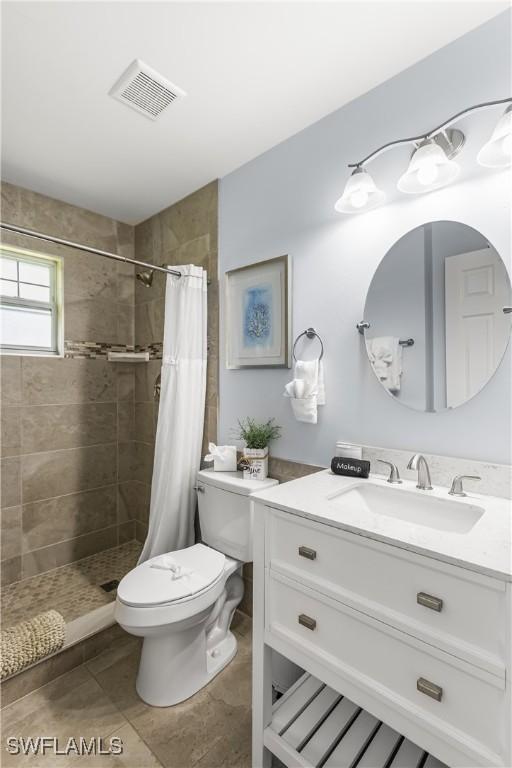 bathroom featuring walk in shower, vanity, and toilet