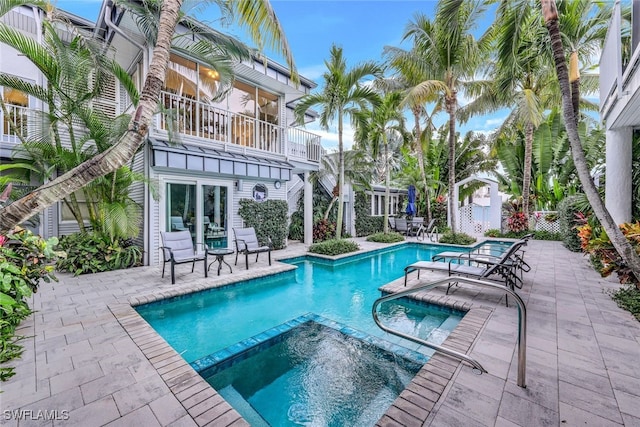 view of pool with an in ground hot tub and a patio