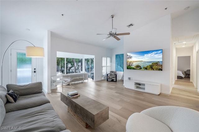 living room featuring high vaulted ceiling, light hardwood / wood-style floors, and ceiling fan