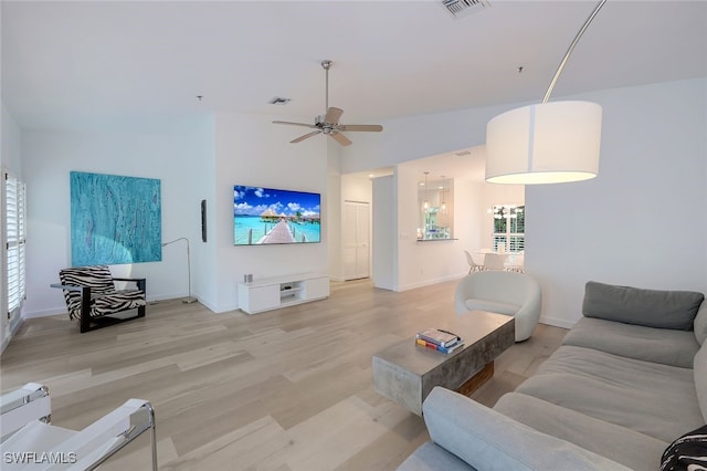 living room featuring light hardwood / wood-style flooring and ceiling fan