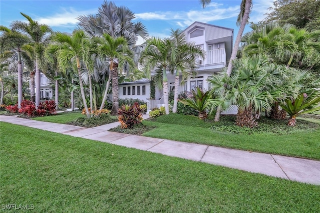 view of front facade with a balcony and a front lawn