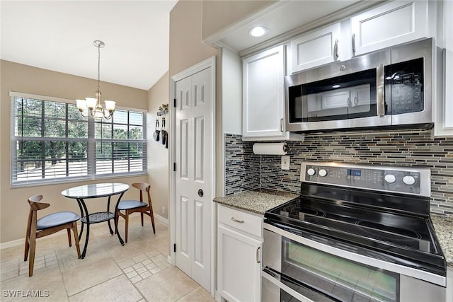 kitchen featuring decorative backsplash, white cabinets, appliances with stainless steel finishes, and dark stone countertops