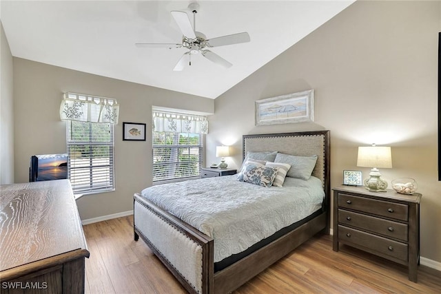 bedroom featuring ceiling fan, light hardwood / wood-style floors, and lofted ceiling