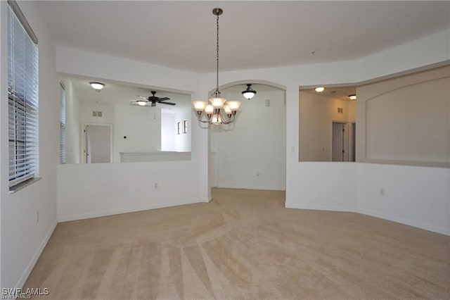 spare room with light colored carpet and a notable chandelier