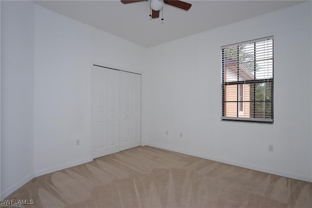 spare room featuring light carpet and ceiling fan