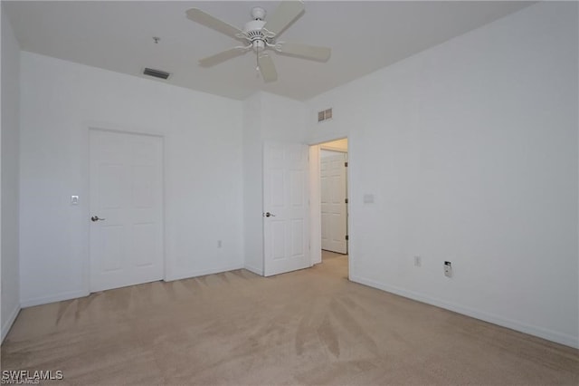 spare room with ceiling fan and light colored carpet