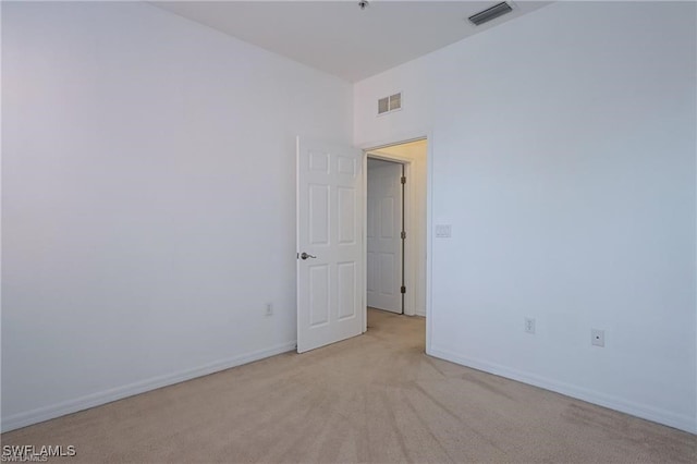 unfurnished room featuring light carpet