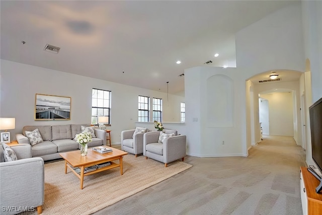 living room featuring high vaulted ceiling and light colored carpet