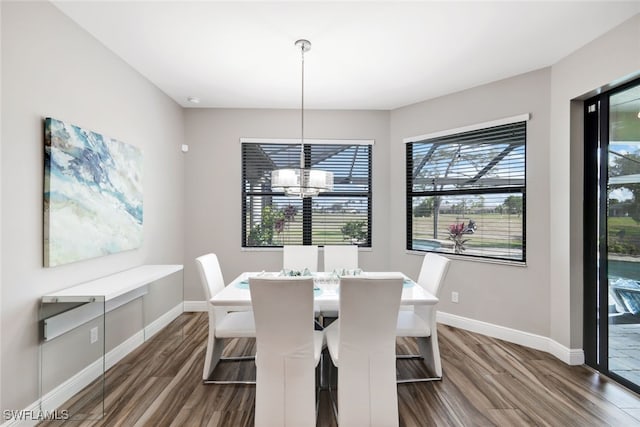 dining area with dark hardwood / wood-style flooring and a notable chandelier