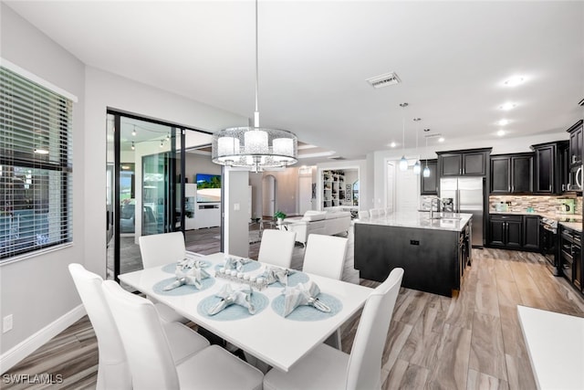 dining room featuring sink and a notable chandelier