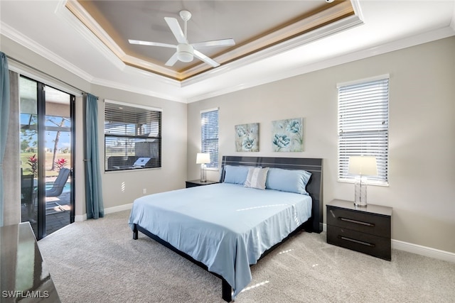 carpeted bedroom featuring a raised ceiling, ceiling fan, multiple windows, and ornamental molding