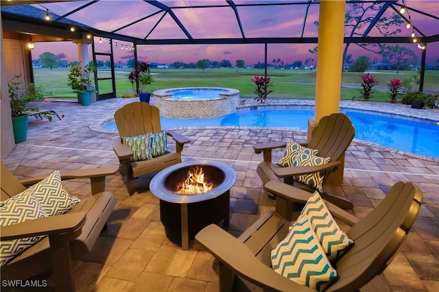 pool at dusk featuring a lanai, an outdoor fire pit, a patio area, and an in ground hot tub