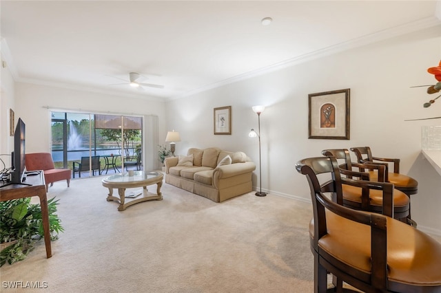 carpeted living room with ceiling fan and ornamental molding