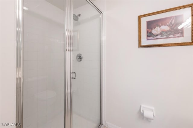 bathroom featuring a shower with door