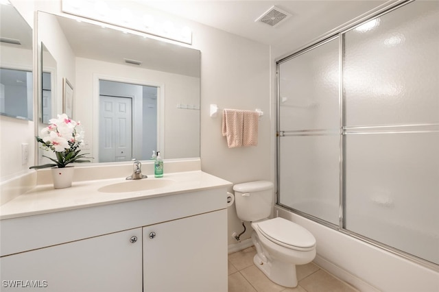 full bathroom with tile patterned floors, toilet, vanity, and combined bath / shower with glass door