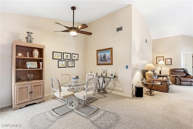 carpeted dining space featuring ceiling fan and vaulted ceiling