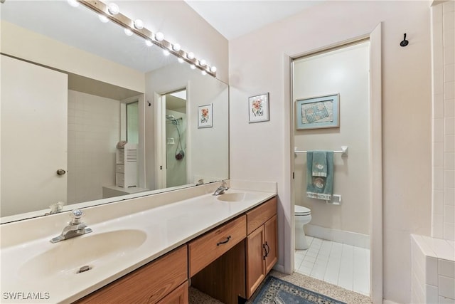 bathroom with toilet, vanity, and tile patterned floors