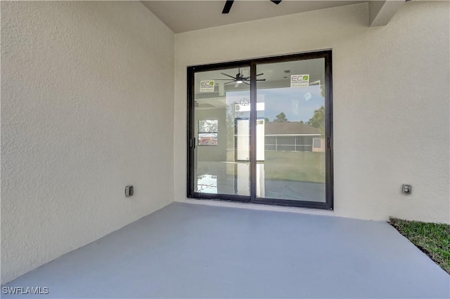 doorway to property featuring a patio area, ceiling fan, and stucco siding