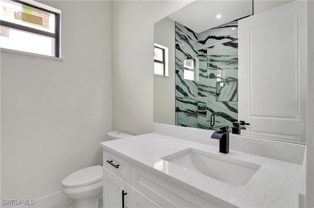 full bathroom with vanity, a marble finish shower, and toilet