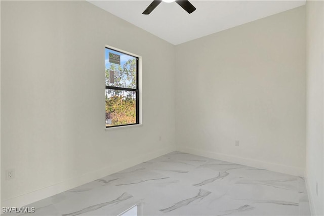 unfurnished room with marble finish floor, ceiling fan, and baseboards