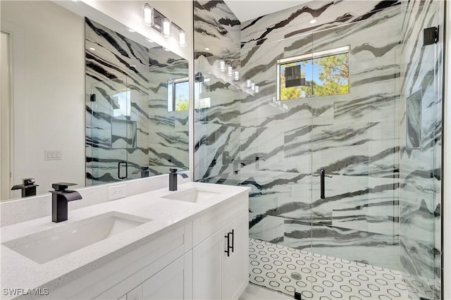 bathroom with a healthy amount of sunlight, a marble finish shower, and a sink