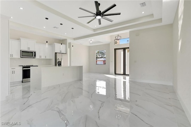 interior space with marble finish floor, visible vents, appliances with stainless steel finishes, and a tray ceiling