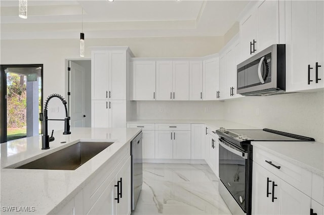 kitchen featuring appliances with stainless steel finishes, light stone counters, marble finish floor, pendant lighting, and a sink