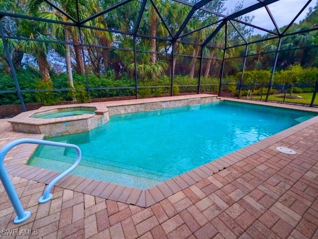 view of pool with glass enclosure, a patio area, and an in ground hot tub