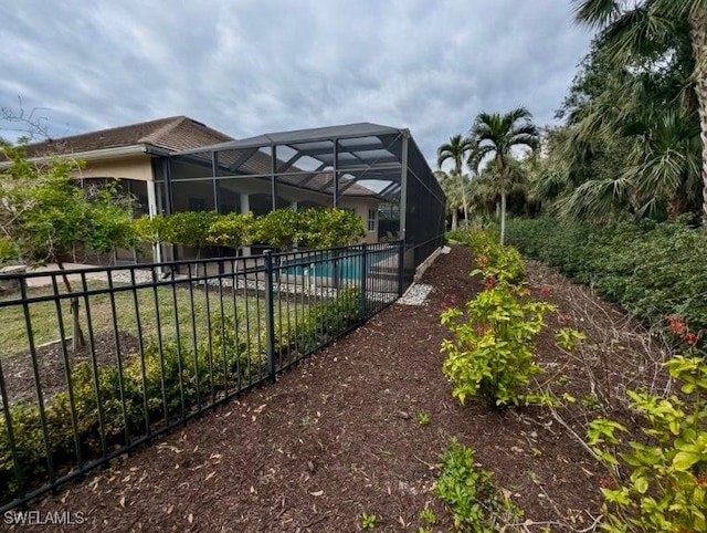 view of yard with a fenced in pool and glass enclosure