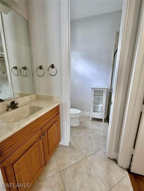 bathroom featuring toilet, tile patterned floors, and vanity