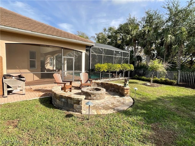 view of yard featuring glass enclosure, a sunroom, a patio area, and a fire pit