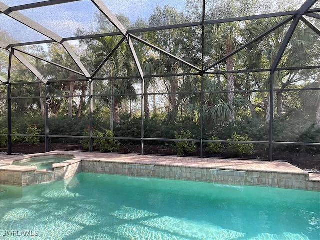 view of swimming pool with an in ground hot tub and a lanai