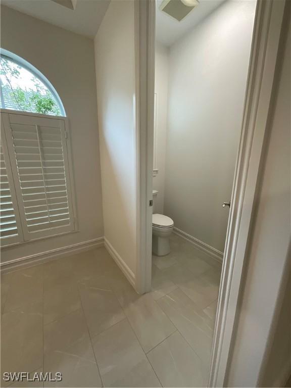 bathroom with toilet and tile patterned flooring