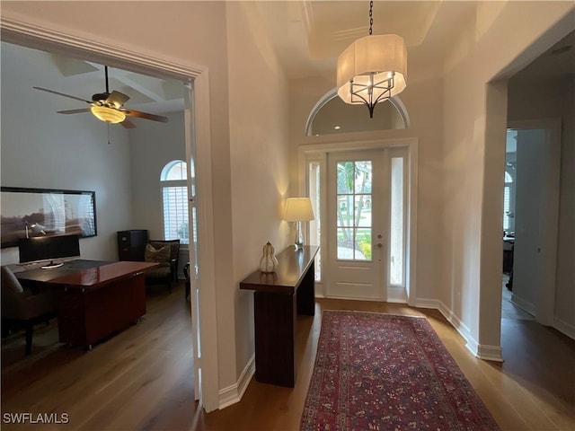 foyer with ceiling fan, hardwood / wood-style floors, and a towering ceiling