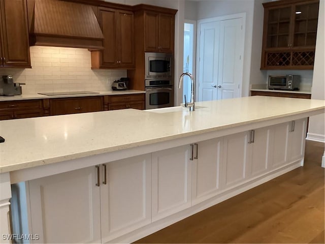 kitchen featuring stainless steel appliances, dark hardwood / wood-style floors, backsplash, wall chimney range hood, and sink