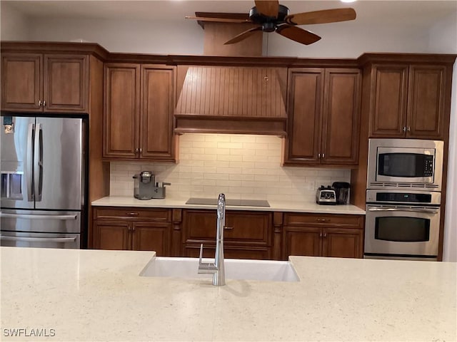 kitchen featuring tasteful backsplash, sink, stainless steel appliances, and custom exhaust hood