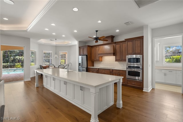 kitchen featuring a breakfast bar, stainless steel appliances, a spacious island, custom range hood, and white cabinets