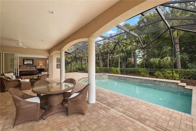 view of pool featuring a lanai, an in ground hot tub, ceiling fan, an outdoor hangout area, and a patio