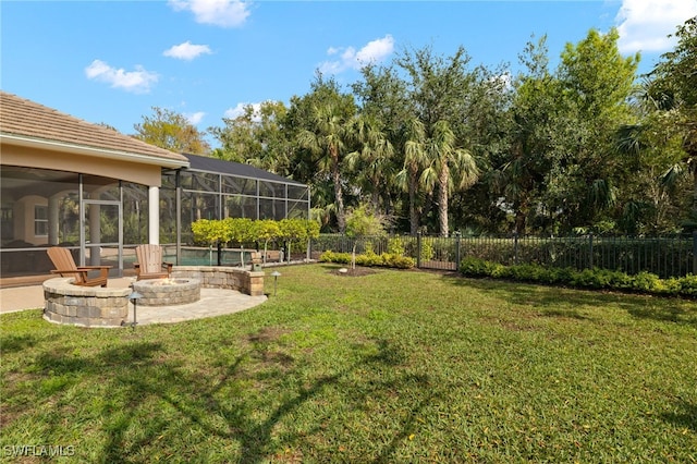 view of yard featuring a lanai, a patio area, and an outdoor fire pit