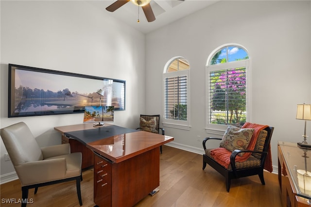 home office featuring lofted ceiling, a wealth of natural light, ceiling fan, and light wood-type flooring