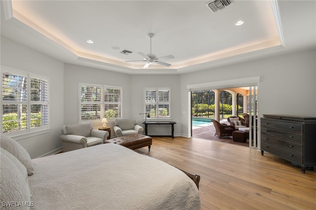 bedroom with a raised ceiling, ceiling fan, access to exterior, and light hardwood / wood-style floors