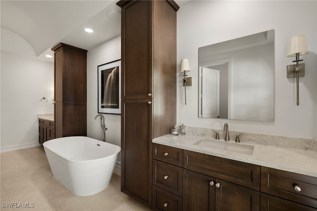 bathroom with tile patterned floors, vanity, and a bath